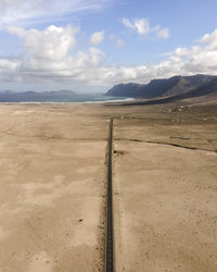 Aerial view of a straight road crossing a desert valley near caleta de famara in lanzarote