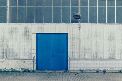 Facade of a factory building with blue gate and lighting