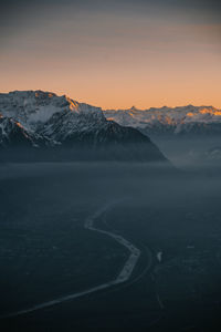 Scenic view of snowcapped mountains against sky during sunset