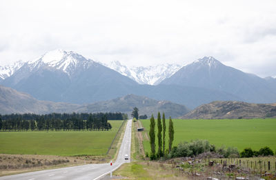 Road leading towards mountains against sky