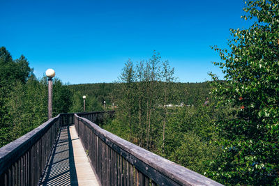 Footbridge against clear blue sky