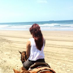 Rear view of woman looking at sea against sky