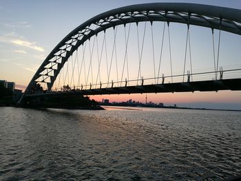 Bridge over river against sky during sunset