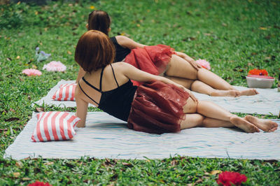 Rear view of women lying on grass