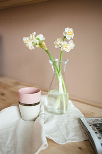 Close up still life with white narcissus, cup of tea, linen towel.