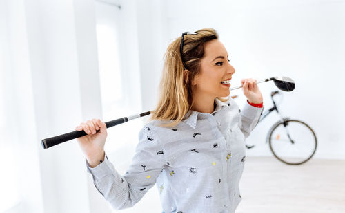 Woman holding golf club in creative office