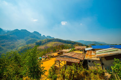 Scenic view of house and mountains against sky