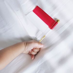 Close-up of hand holding red paper