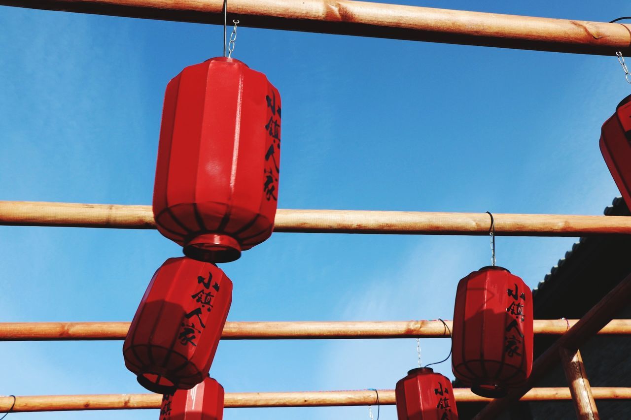 red, hanging, sky, no people, day, focus on foreground, close-up, nature, metal, clear sky, blue, outdoors, lighting equipment, text, low angle view, positive emotion, love, lantern, sunlight