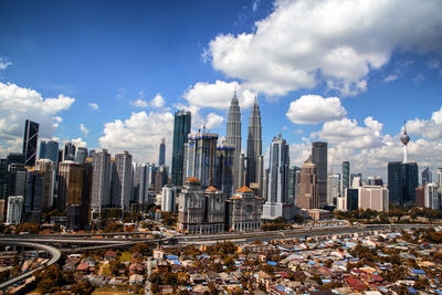 Modern buildings in city against cloudy sky