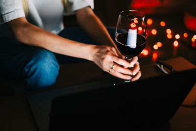 Midsection of man drinking glass