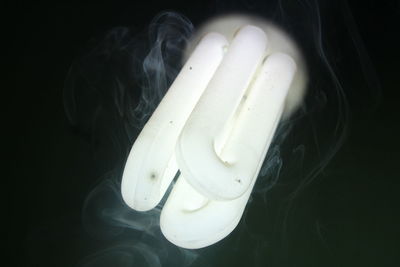 Close-up of illuminated light bulb against black background