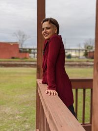 Side view of smiling young woman standing outdoors