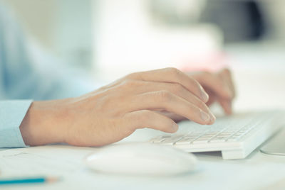 Midsection of person using laptop on table