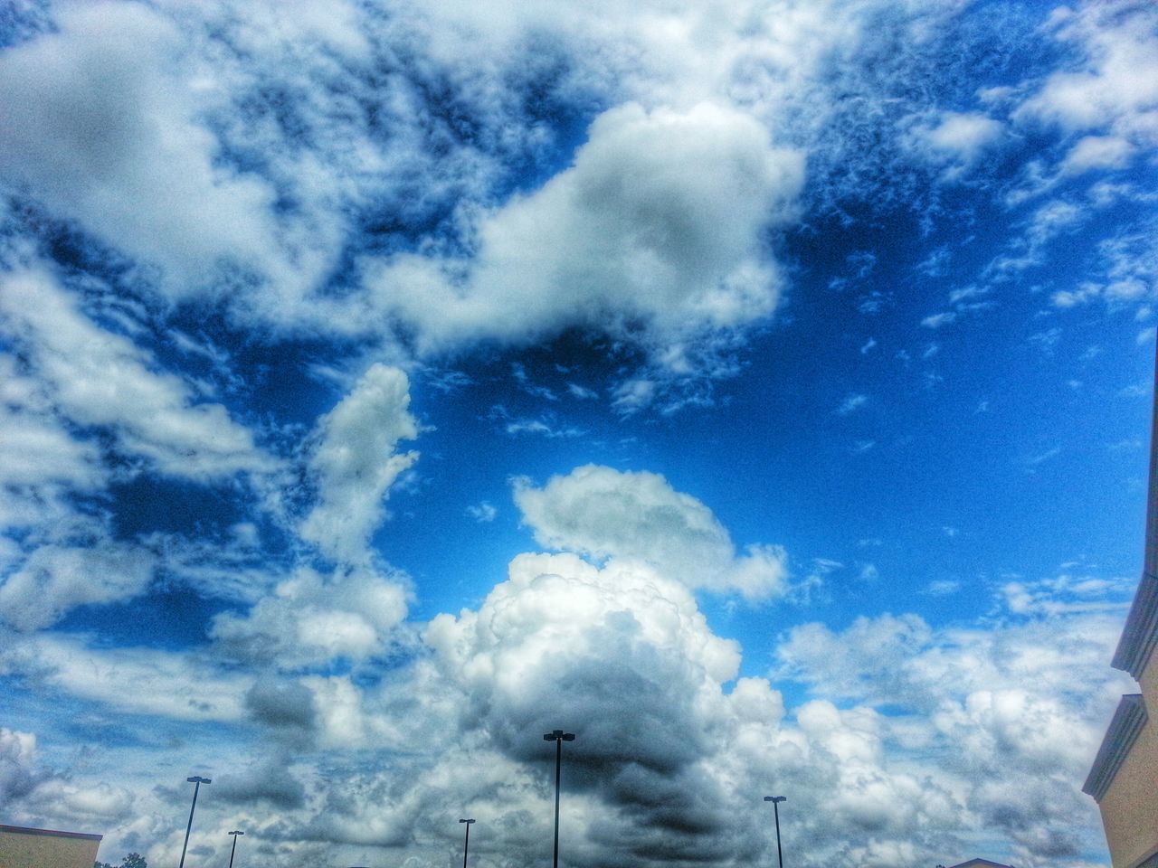 sky, cloud - sky, low angle view, cloudy, blue, cloud, cloudscape, nature, beauty in nature, weather, white color, day, tranquility, scenics, outdoors, no people, white, tranquil scene, built structure, high section