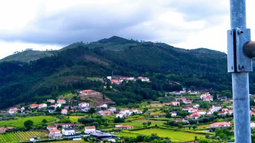 Aerial view of townscape by mountain against sky