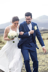 Low angle view of couple holding bouquet