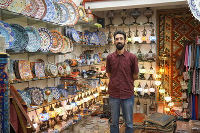 Full length portrait of young man standing in store