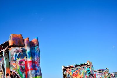 Low angle view of multi colored built structure against blue sky