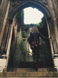 Rear view of woman walking in corridor of building