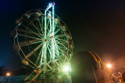 Low angle view of ferris wheel at night