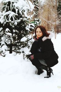 Portrait of smiling young woman standing in snow