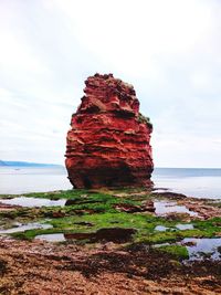 Rock formation in sea against sky