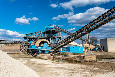 Machine for transferring gravel, spoil for transport belts on blue sky at an industrial cement