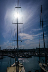 Sailboats moored at harbor