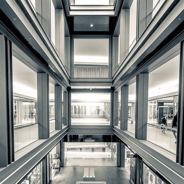 indoors, architecture, built structure, corridor, ceiling, architectural column, modern, window, column, glass - material, empty, flooring, incidental people, building, day, transparent, sunlight, tiled floor, absence, railing