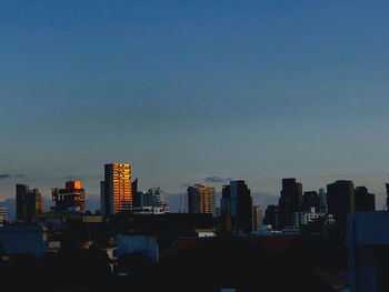 Modern buildings in city against clear sky