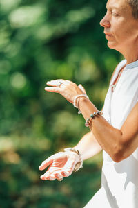 Tai chi in nature. mature woman exercising tai chi in nature, close up on hands