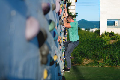 Rear view of woman standing by fence