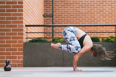 Full length lifestyle portrait of woman doing yoga