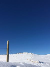 Snow covered mountain against clear blue sky