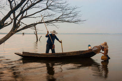 Man on boat in sea against sky