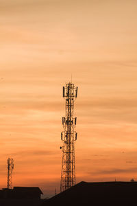 Silhouette of communications tower against sky during sunset