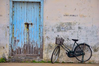 Bicycle parked by old blue door