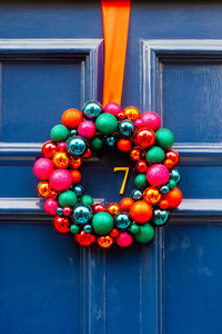 Christmas wreath consisting of colorful glass baubles on blue front door number 7 in london 