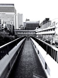 Bridge over canal amidst buildings against clear sky