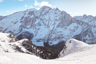 Snow covered mountains in belvedere ski area, dolomiti superski resort