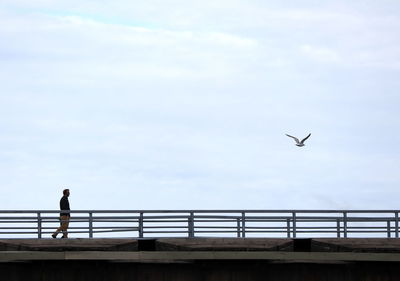 Low angle view of man flying against sky