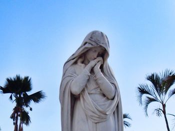 Low angle view of statue against clear blue sky