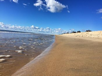 Scenic view of beach against blue sky