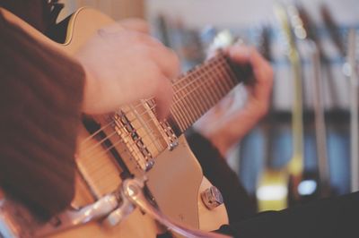 Midsection of man playing guitar