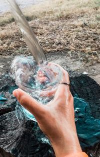 Close-up of hand filling water in glass