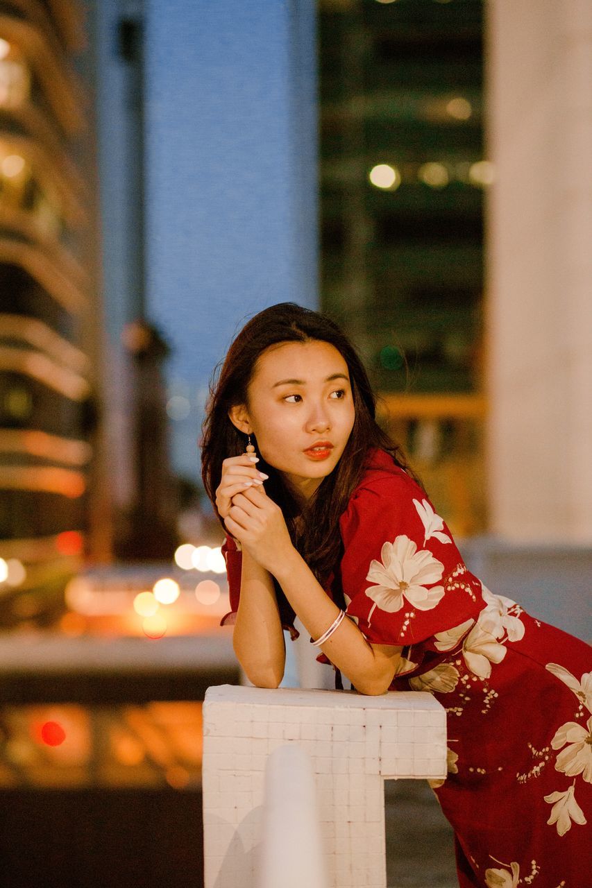 one person, young adult, real people, women, young women, leisure activity, lifestyles, looking at camera, portrait, focus on foreground, architecture, front view, three quarter length, holding, adult, standing, casual clothing, waist up, beautiful woman, hairstyle, architectural column