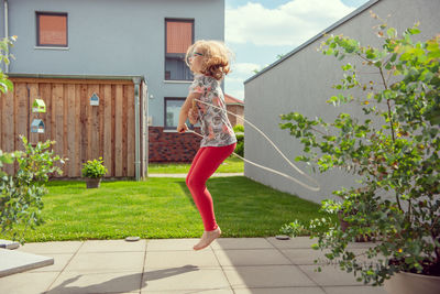 Woman jumping against plants