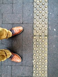 Low section of man standing on paved street