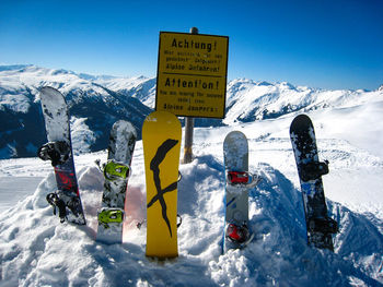 Information sign on snow covered mountain against sky